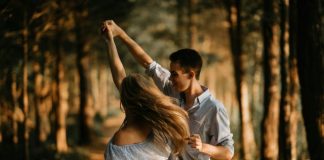 man and woman dancing at center of trees