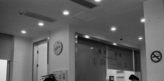 a black and white photo of a woman standing in front of a counter