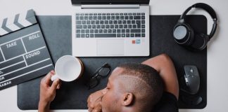 a man sitting at a desk with a laptop and headphones