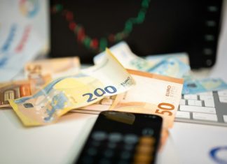 How to Rebuild Credit After Bankruptcy or Debt Settlement A cell phone sitting on top of a pile of money