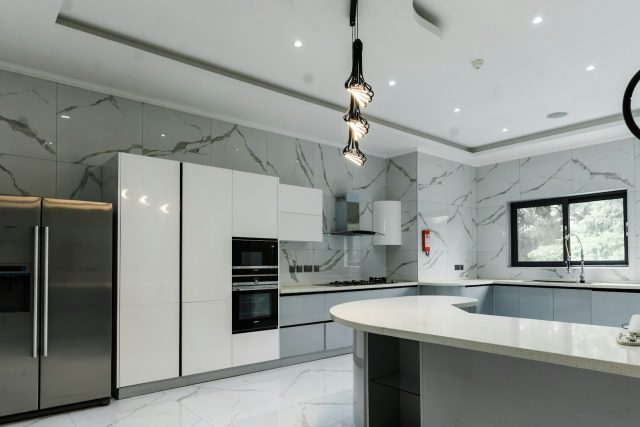 Photo by Emmanuel Ikwuegbu a modern kitchen with marble counter tops and stainless steel appliances