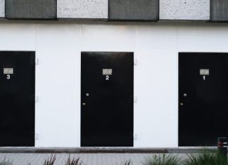 Why Should You Consider Material Quality Before Choosing Hinges? black door on white concrete wall