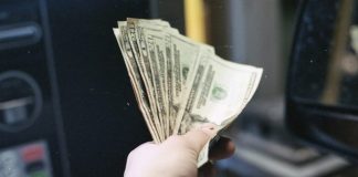 person holding fan of us dollar bill