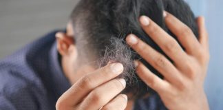 a man is combing his hair with his hands