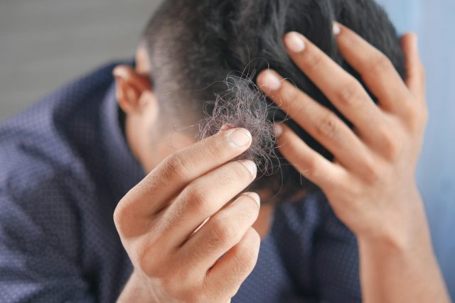 Photo by Towfiqu barbhuiya a man is combing his hair with his hands