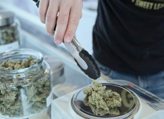 Weed Delivery Services: Convenience at Your Doorstep person holding grey tongs and kush