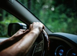 What To Know Before Choosing A Yoke Over A Round Wheel In EVs person holding car steering wheel