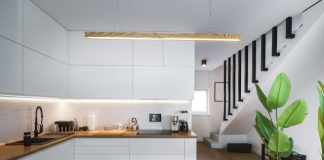 A kitchen with a wooden counter top next to a plant