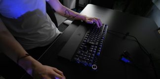 A person sitting at a desk with a keyboard and mouse