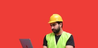 a man in a yellow hard hat holding a tablet