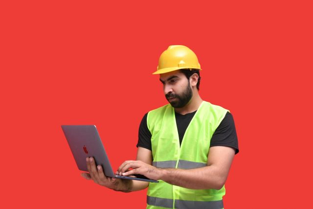 Photo by Fotos a man in a yellow hard hat holding a tablet
