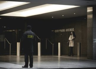 Armed vs Unarmed Security: Which One is Best for You? security guard standing on the gray floor