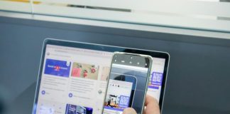 a person holding a cell phone and a laptop