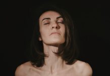 a woman with her eyes closed in the dark