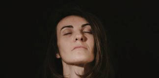 a woman with her eyes closed in the dark