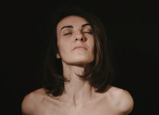Crepey Skin Treatments That Actually Make a Difference a woman with her eyes closed in the dark