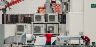 a couple of men standing on top of a roof