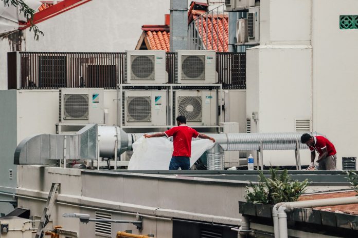 Photo by Singapore Stock Photos a couple of men standing on top of a roof