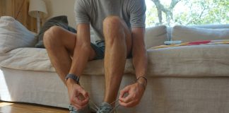 a man sitting on a couch holding his shoes