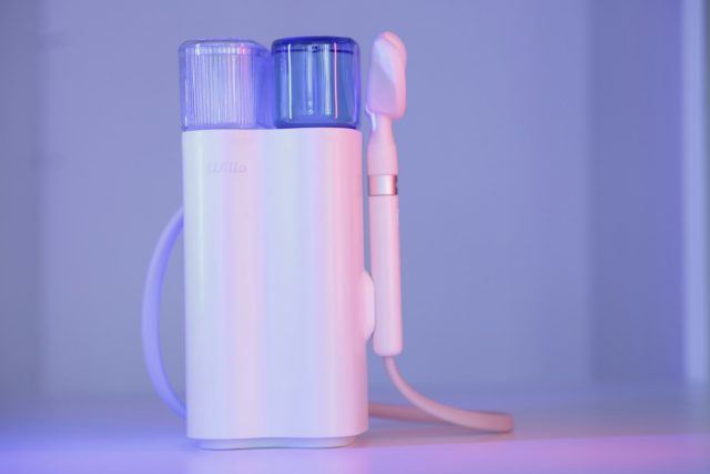 Photo by Willo Team a toothbrush and a toothpaste holder on a table