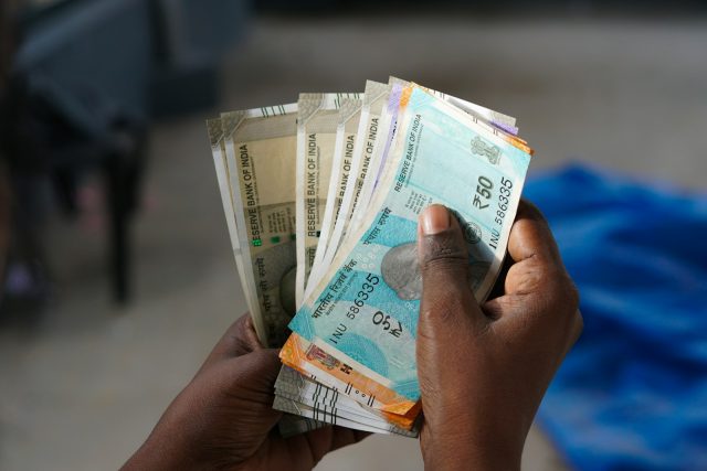 Photo by Dileesh Kumar A person holding a bunch of money in their hand