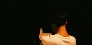 a person standing in the dark with their back to the camera