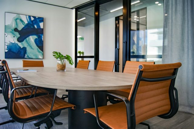 Photo by S O C I A L . C U T brown wooden 9-piece office table and chairs
