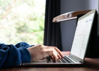 person using macbook pro on table