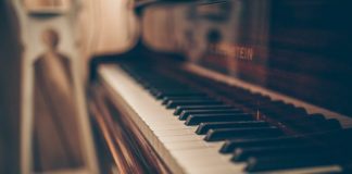 a close up of a piano with a person in the background