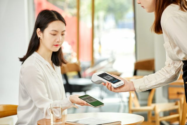 woman in white long sleeve shirt holding white smartphone
