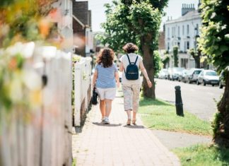 Why Reconnecting Can Change Everything two women walking down sidewalk near fence