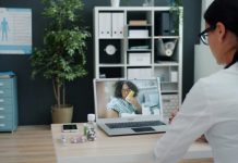 Combining Traditional Rehab With Performance Tech for Faster Results Doctor consulting patient via video call on laptop.