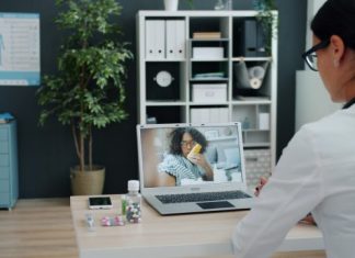 Combining Traditional Rehab With Performance Tech for Faster Results Doctor consulting patient via video call on laptop.