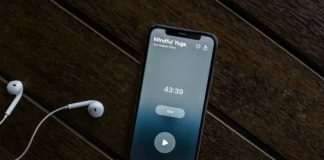 an iphone and ear buds on a wooden table