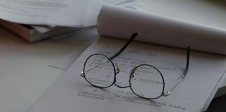 black framed eyeglasses on top of white printing paper