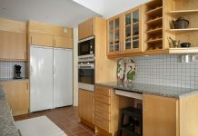 7 Budget-Friendly Ways to Upgrade a Kitchen Using New Cabinet Doors A kitchen with wooden cabinets and white appliances