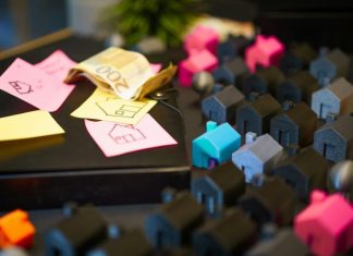 Property Purchase Pitfalls That Skilled Real Estate Lawyers Prevent Miniature houses with euro banknotes and sticky notes.