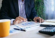 How a managed SIEM system can offer the best defence against cyberattacks and hacking person in black suit jacket holding white tablet computer