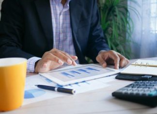 How a managed SIEM system can offer the best defence against cyberattacks and hacking person in black suit jacket holding white tablet computer