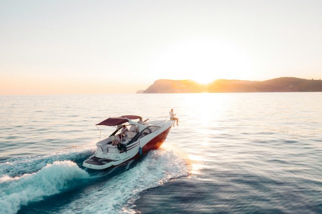 Photo by Ivan Ragozin man riding on white and red boat on sea during daytime