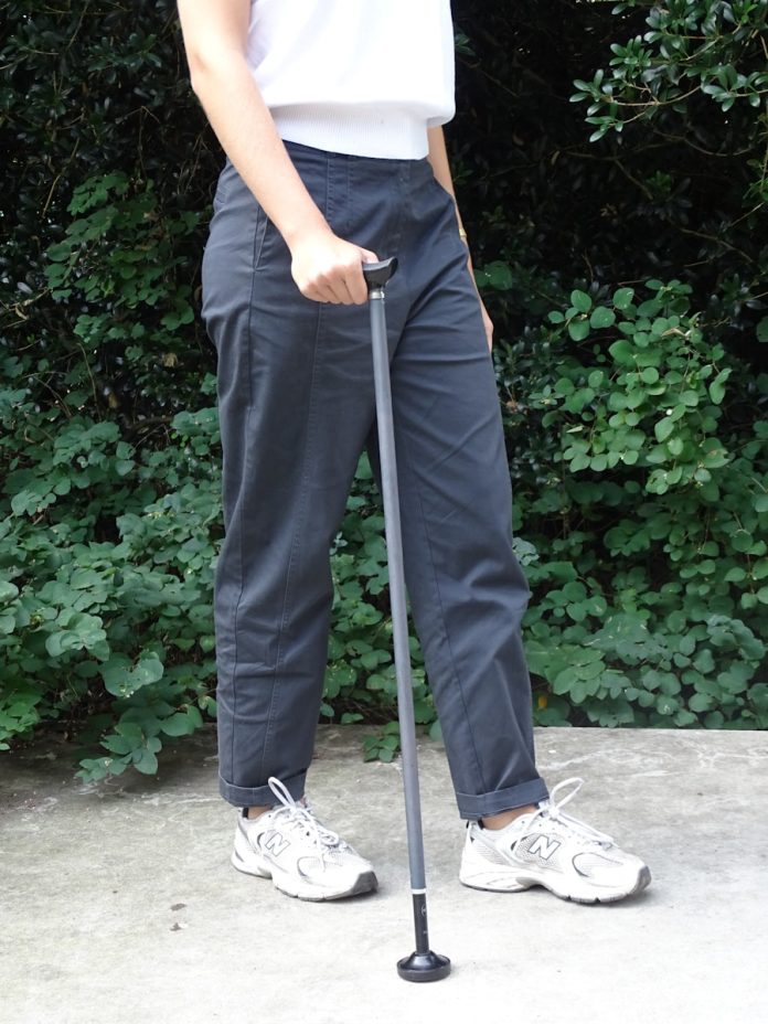 Person holding a walking cane outdoors