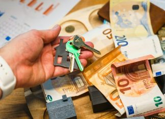 The Quiet Complexity Behind Every Personal Property Dispute Explained Clearly Hand holding house keys over euro banknotes and charts.