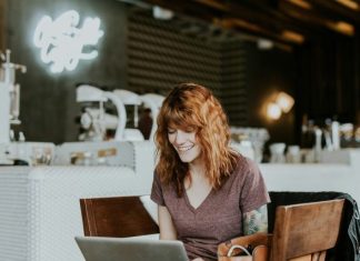 RTP and Volatility of Lightning Link Slots woman sitting on brown wooden chair while using silver laptop computer in room