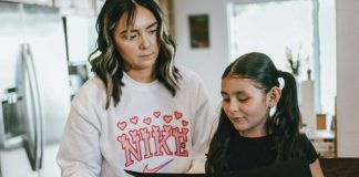 a woman standing next to a little girl in a kitchen