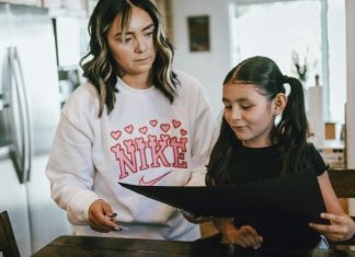 a woman standing next to a little girl in a kitchen