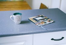 gray and white ceramic mug beside multicolored covered book