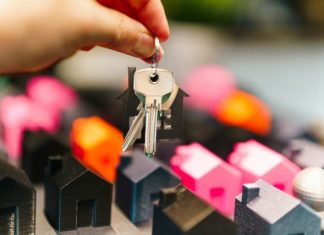 Beyond Signatures: How Law Firms Structure Real Property Transitions Hand holding house keys over miniature houses