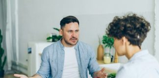 a man sitting at a table talking to a woman