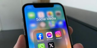 a person holding a cell phone with social media on the screen