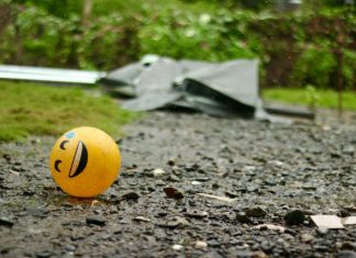 A smiley face ball sitting on a gravel road